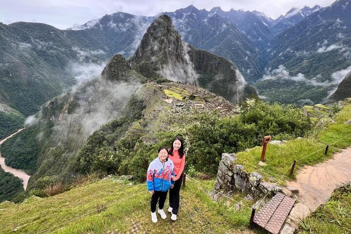 uma mulher e uma criança em pé no topo de uma montanha