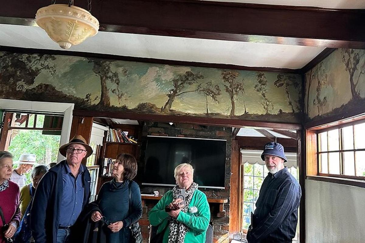 a group of people standing in a room with a painting