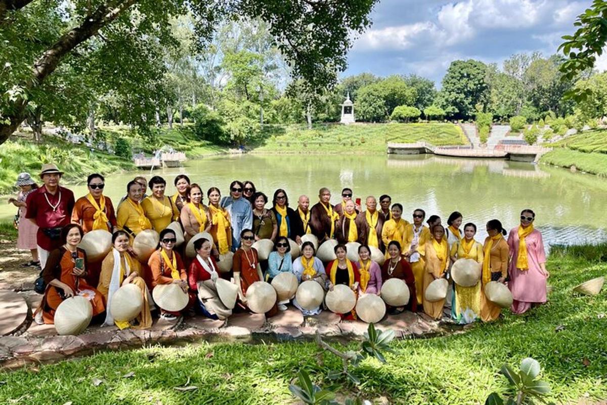 a group of people posing for a picture in front of a pond