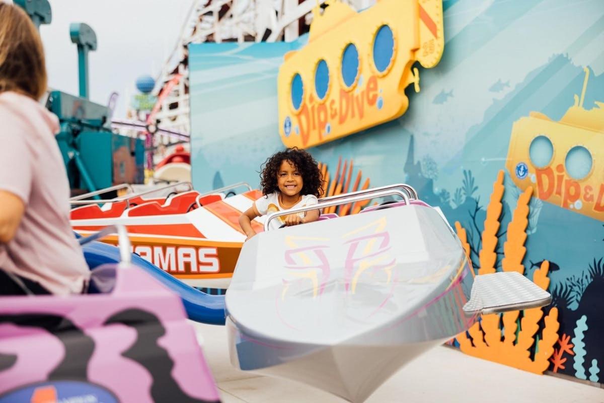 a young girl riding on a ride at a roller coaster