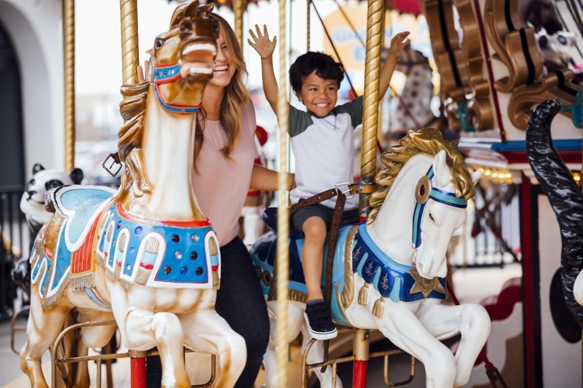 a woman and a boy on a carousel