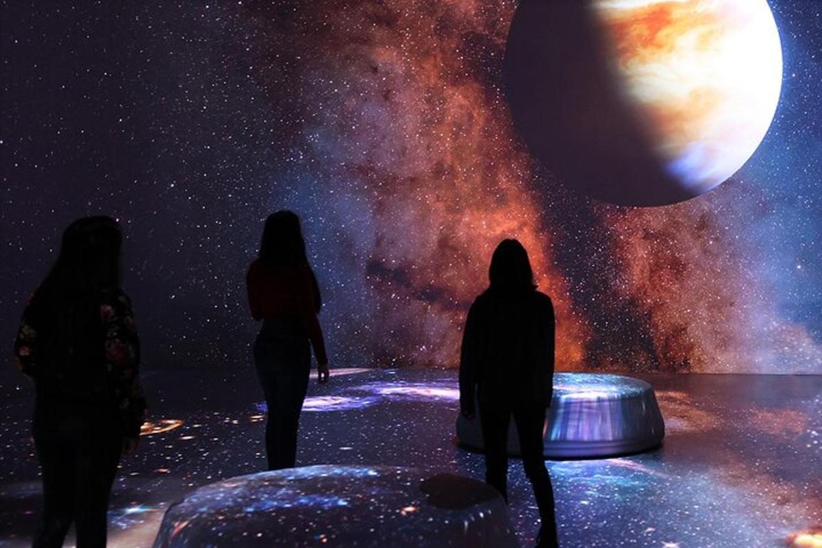 a group of people looking at the universe