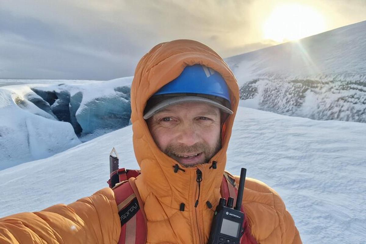 um homem em pé no topo de uma montanha coberta de neve