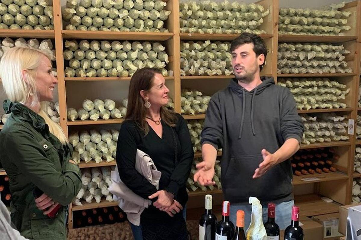 trei persoane care stau într-un magazin cu sticle de vin
