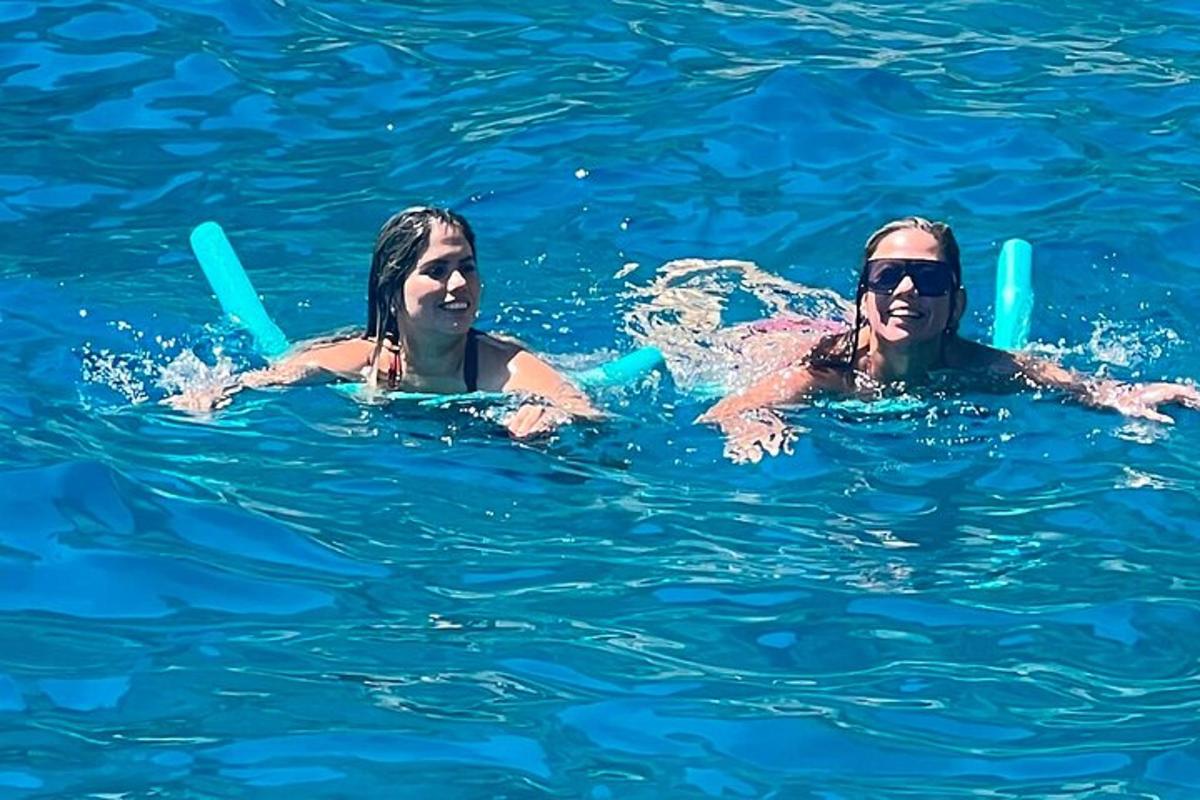 due donne nuotano nell'acqua blu
