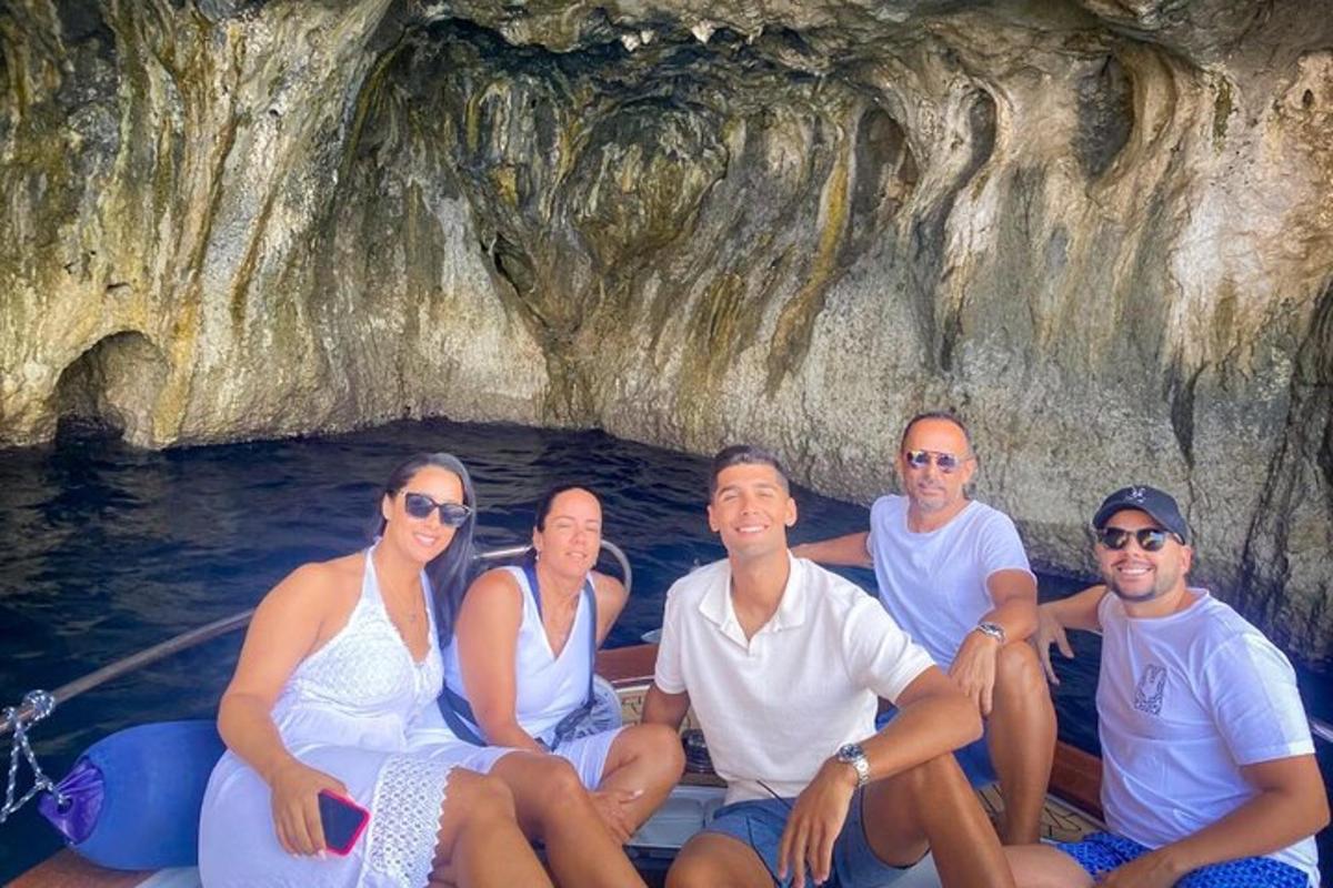 un gruppo di persone sedute su una barca in una grotta