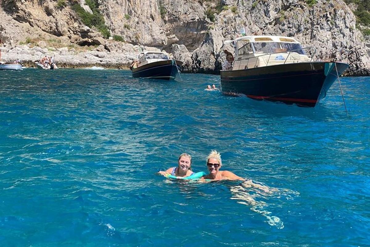 due persone che nuotano nell'acqua accanto alle barche