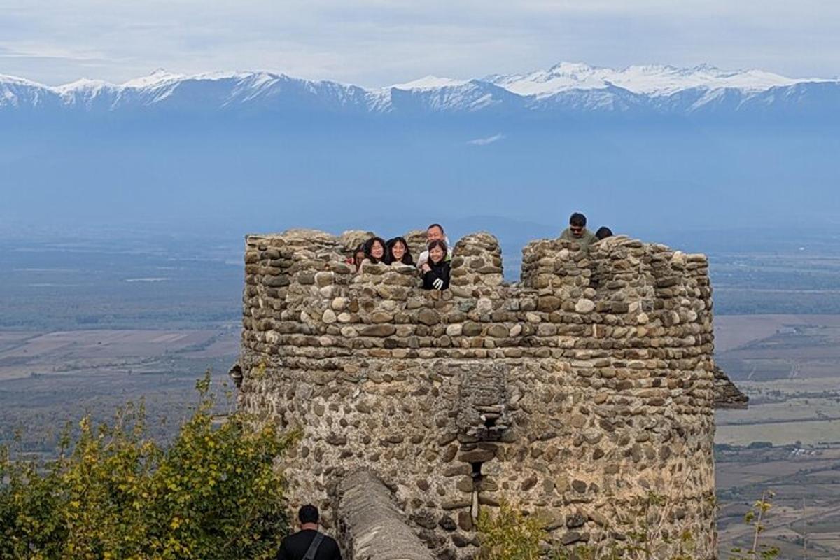 un grup de persones assegudes a sobre d'un mur de pedra