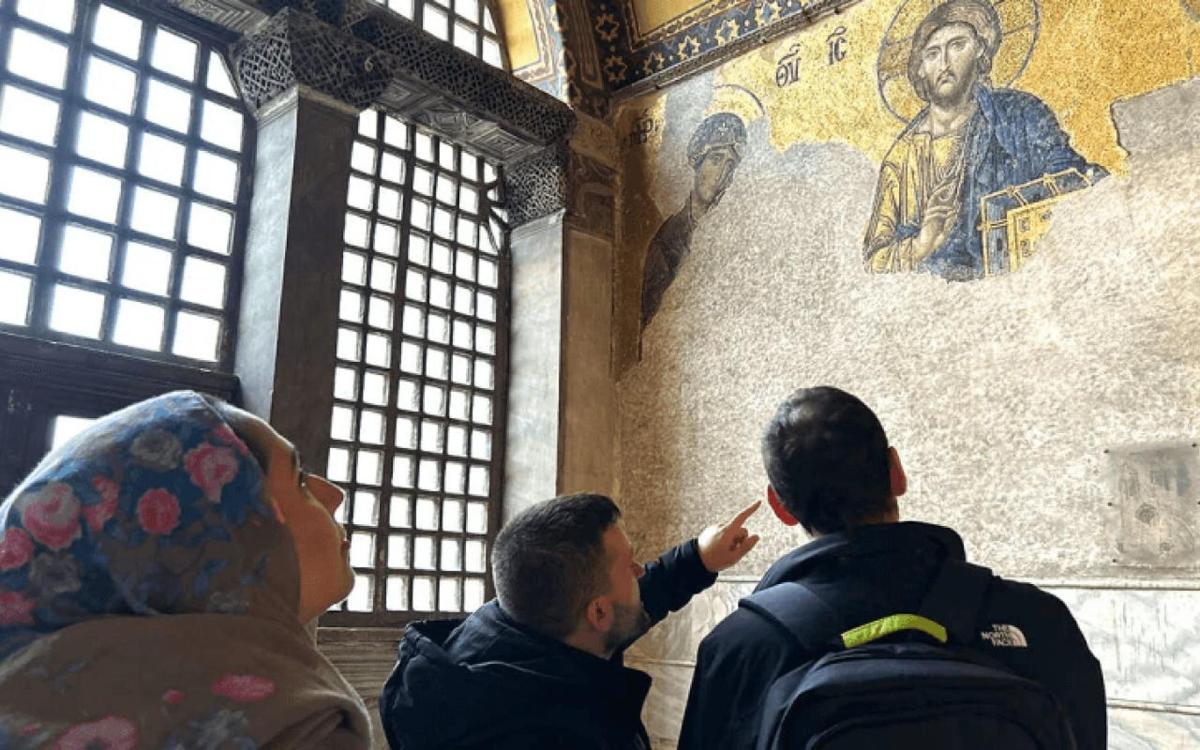 un grup de oameni care privesc un tablou pe un perete