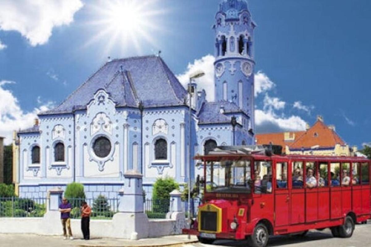 a red trolley in front of a church