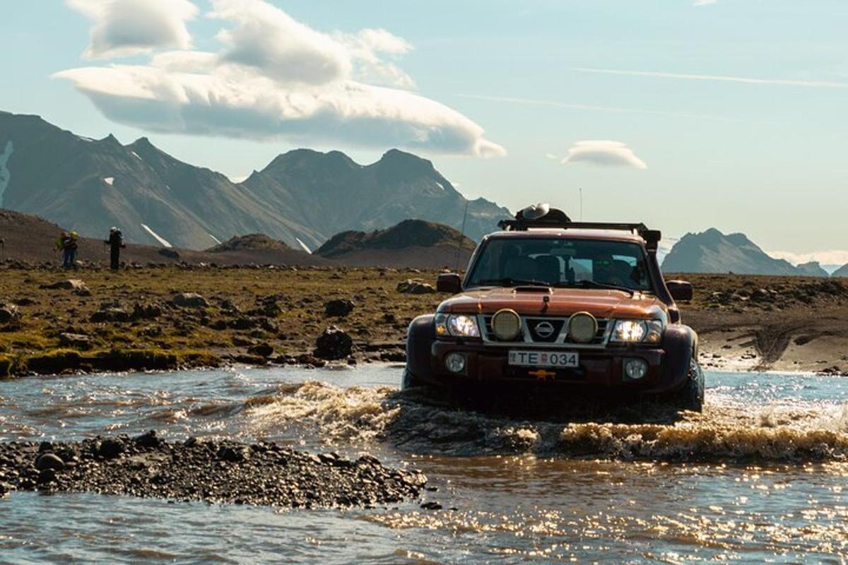 ein Jeep, der durch einen Fluss in der Wüste fährt