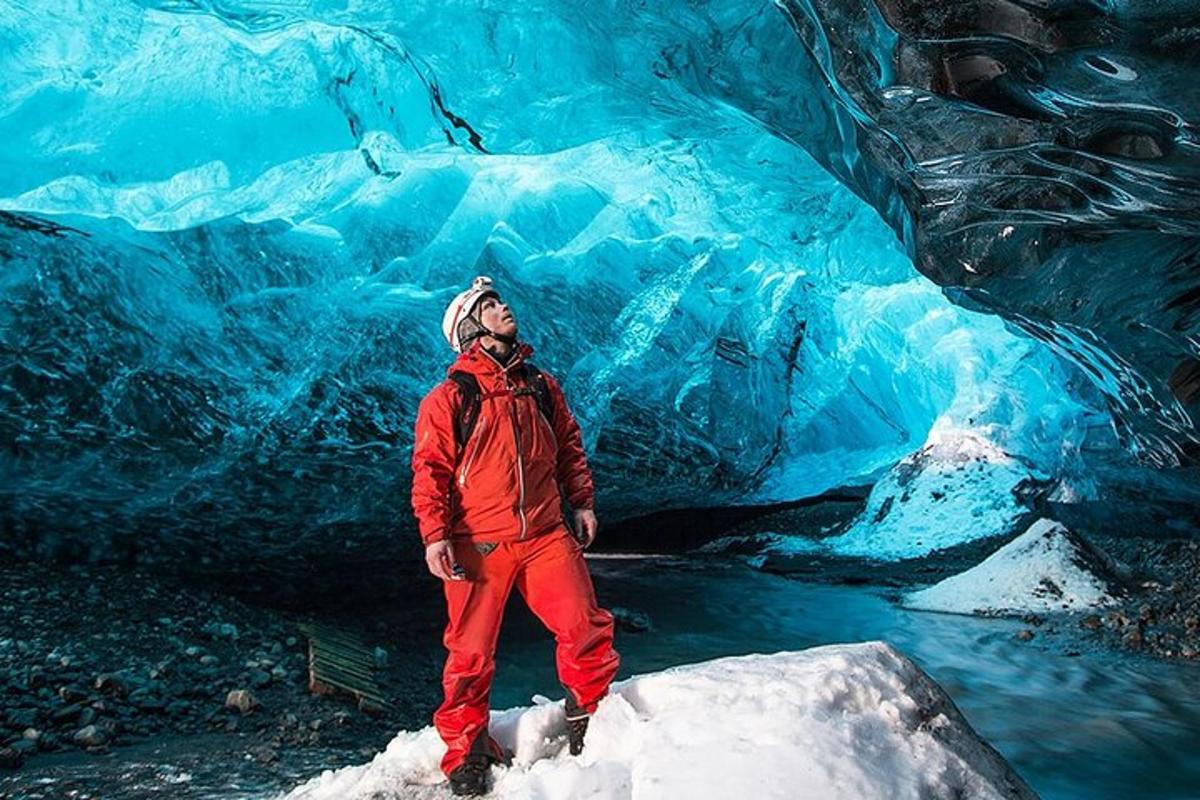 a man standing in front of an ice cave