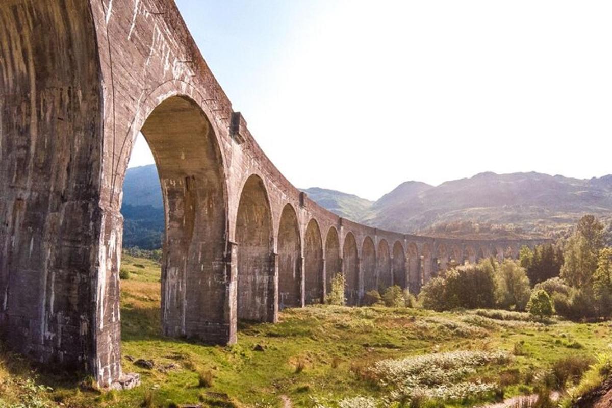 uma ponte velha com arcos em um campo