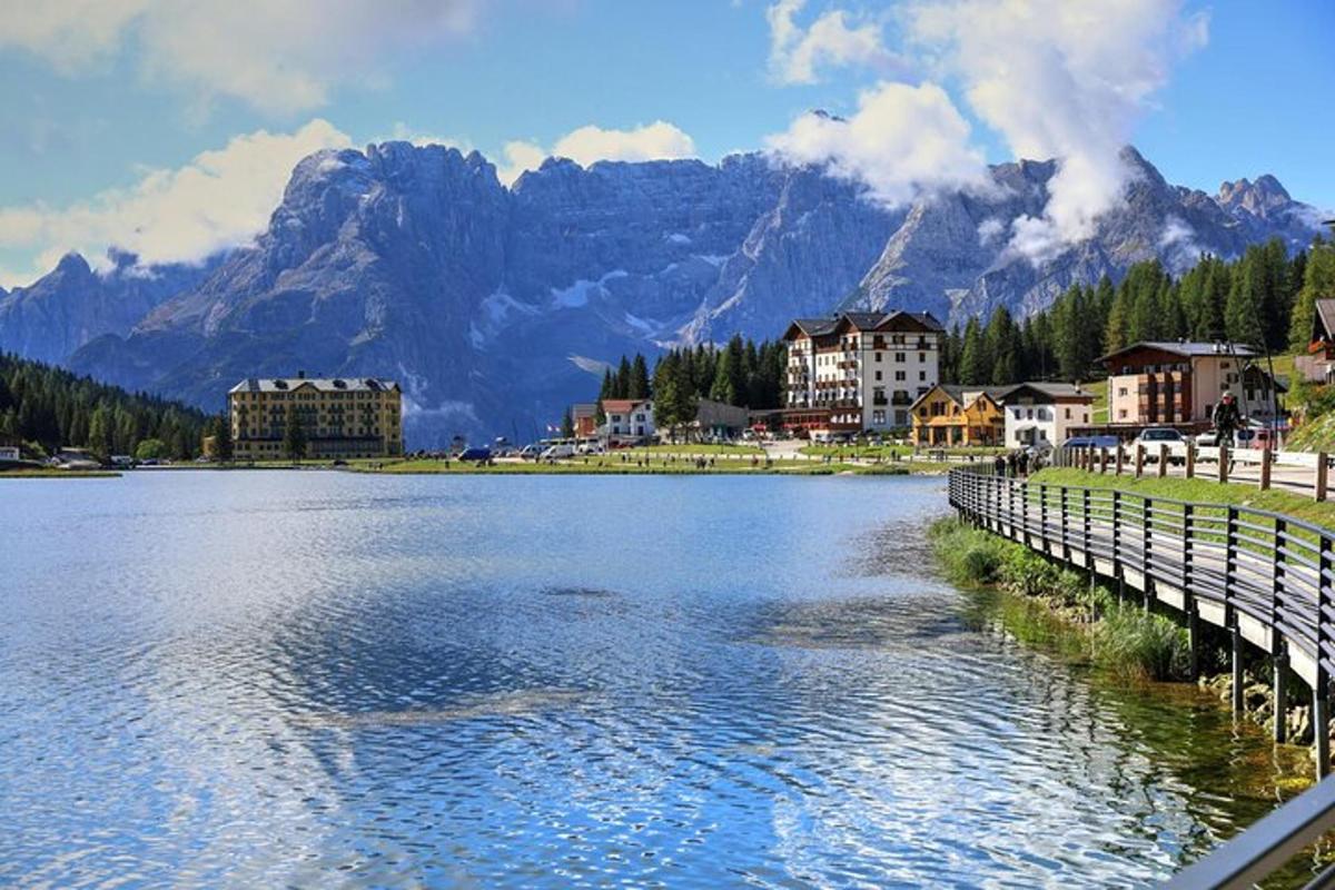 a lake with a town and mountains in the background