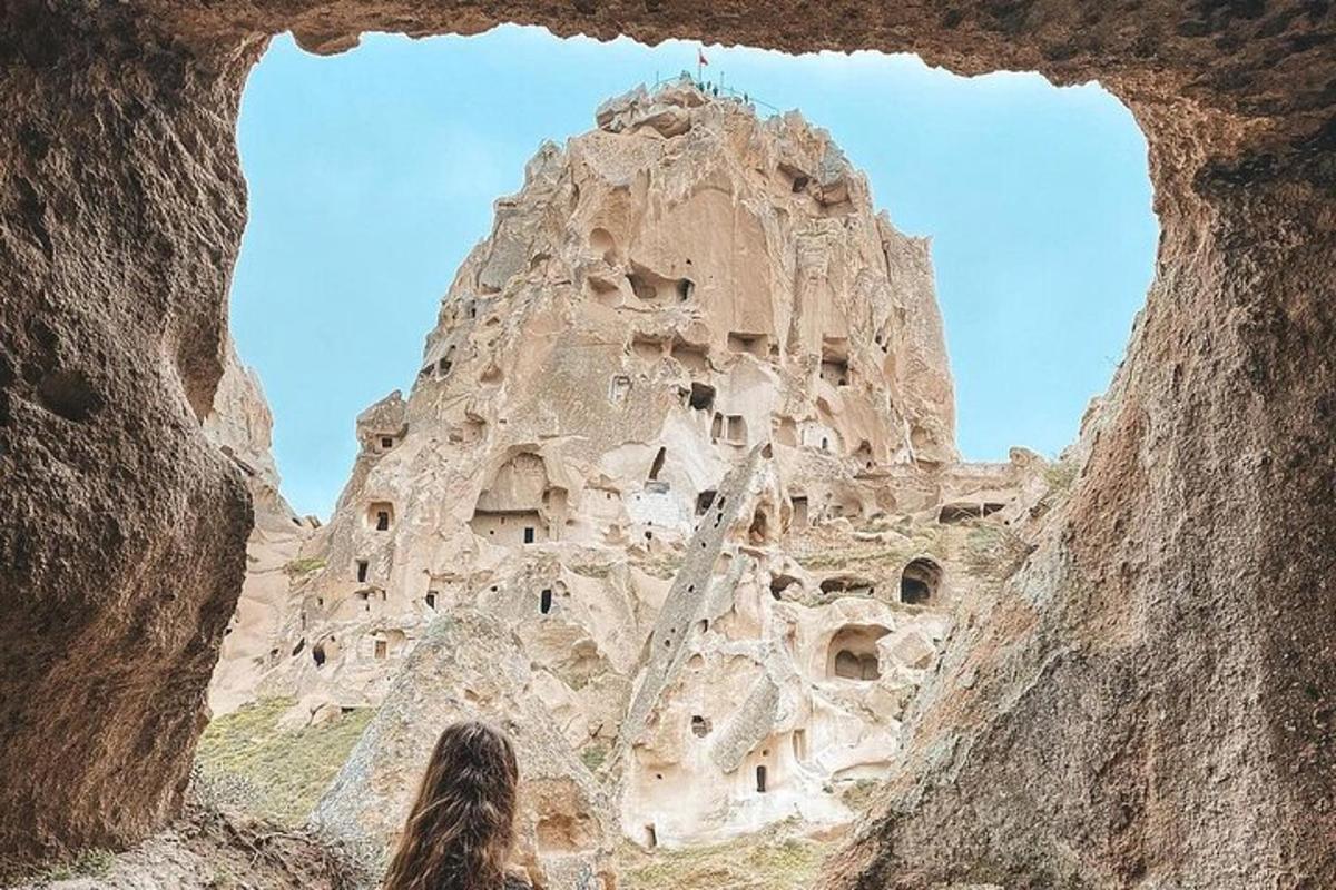 una donna che guarda in alto verso una formazione rocciosa