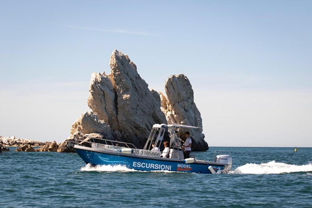 a blue boat in the water near a rock formation