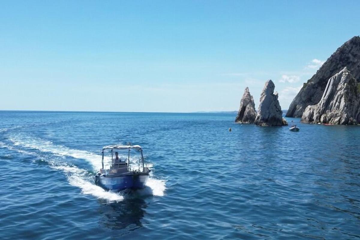 a boat in the water near some rocks