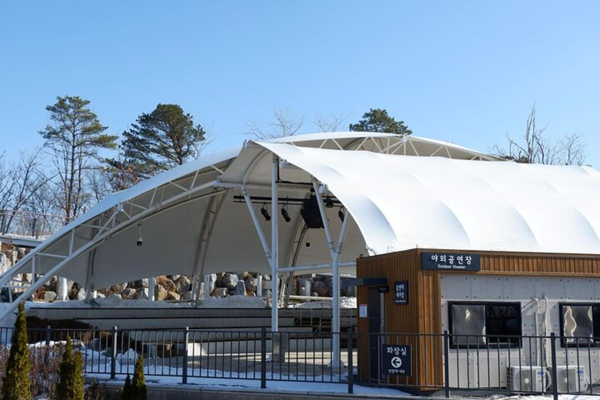 paviljonas su baltu baldakimu priešais pastatą