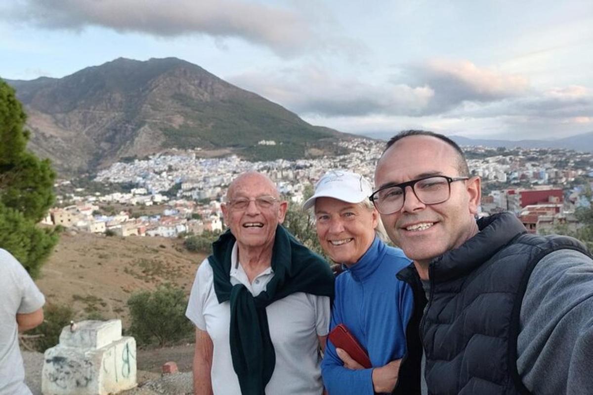 un grup de tres persones dretes al cim d'una muntanya