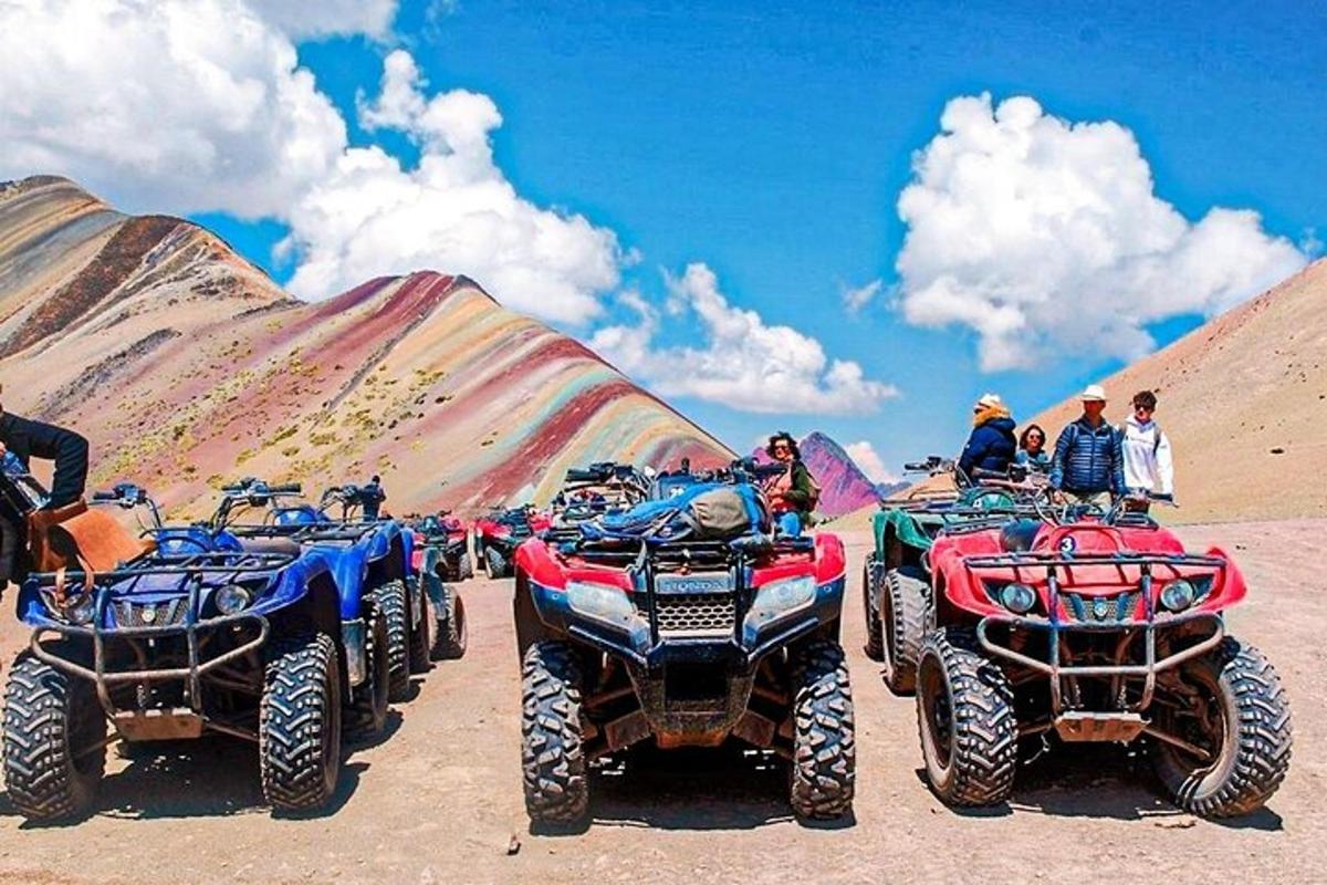 a group of people standing around atvs in the desert