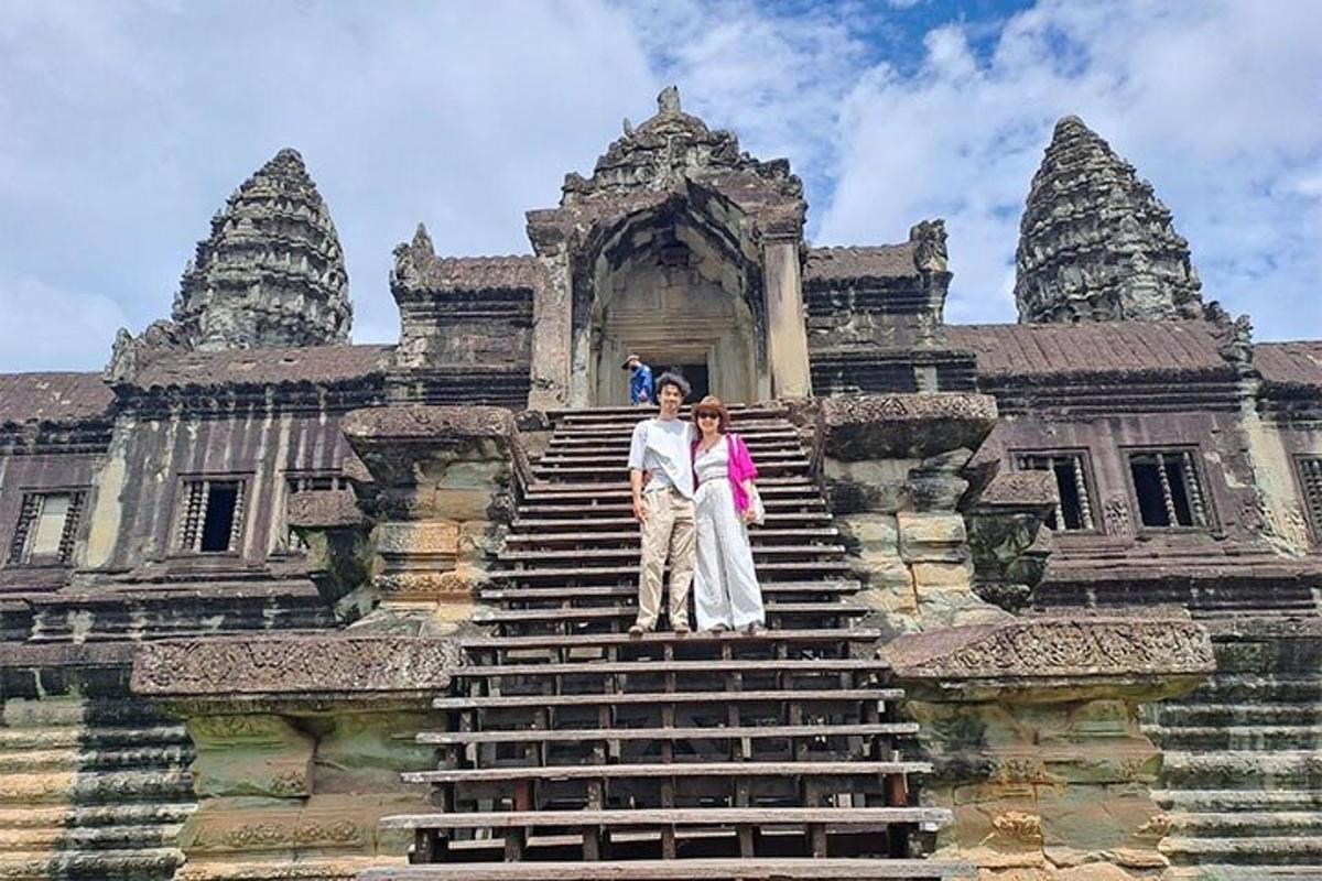 sepasang suami isteri berdiri di atas tangga sebuah bangunan