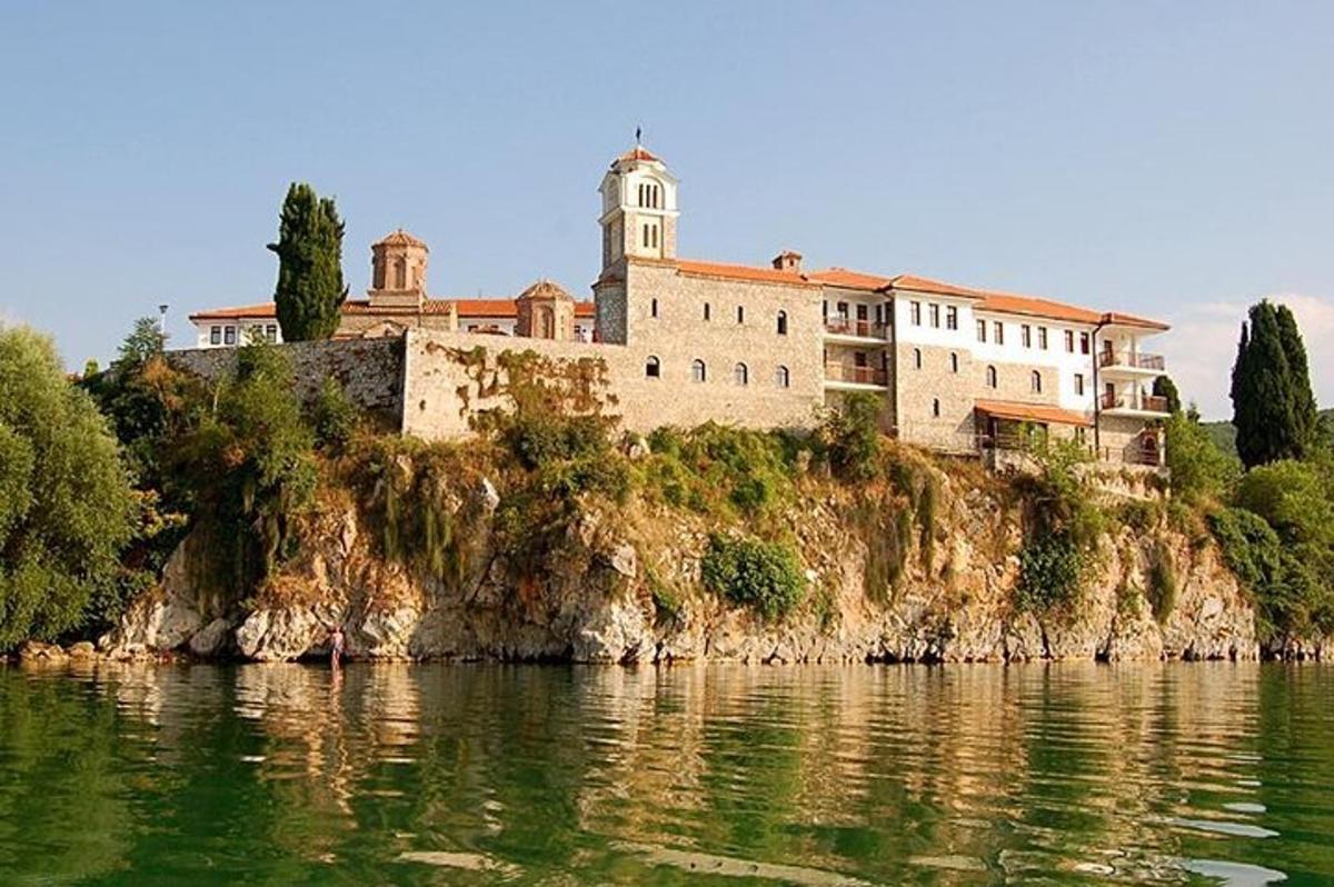 un grande edificio in cima a una collina vicino all'acqua