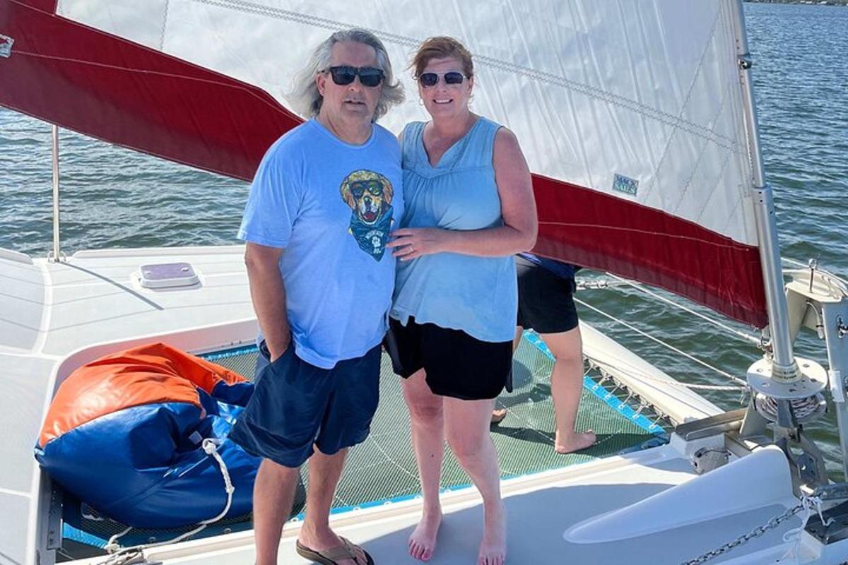 un uomo e una donna in piedi su una barca a vela