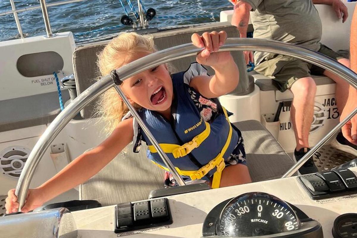 uma jovem grita enquanto dirige um barco