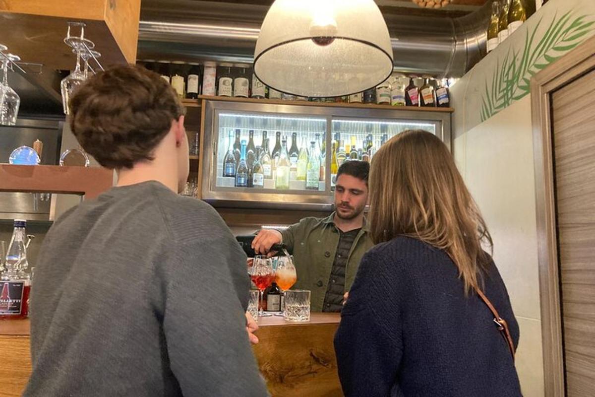 Δύο άτομα στέκονται σε ένα μπαρ με έναν μπάρμαν