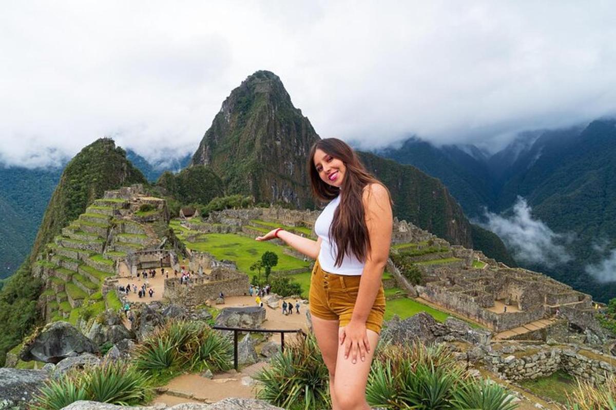 uma mulher em pé no topo de uma montanha
