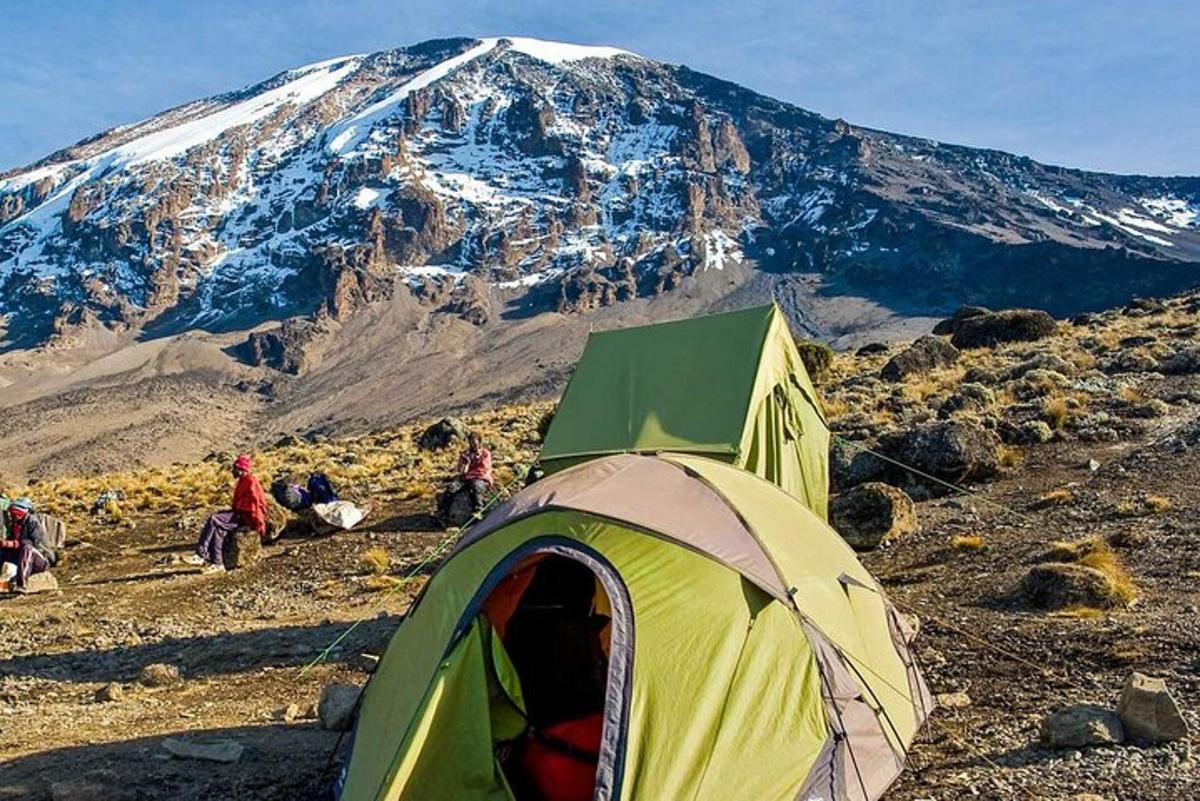 una tenda su una montagna con una montagna coperta di neve