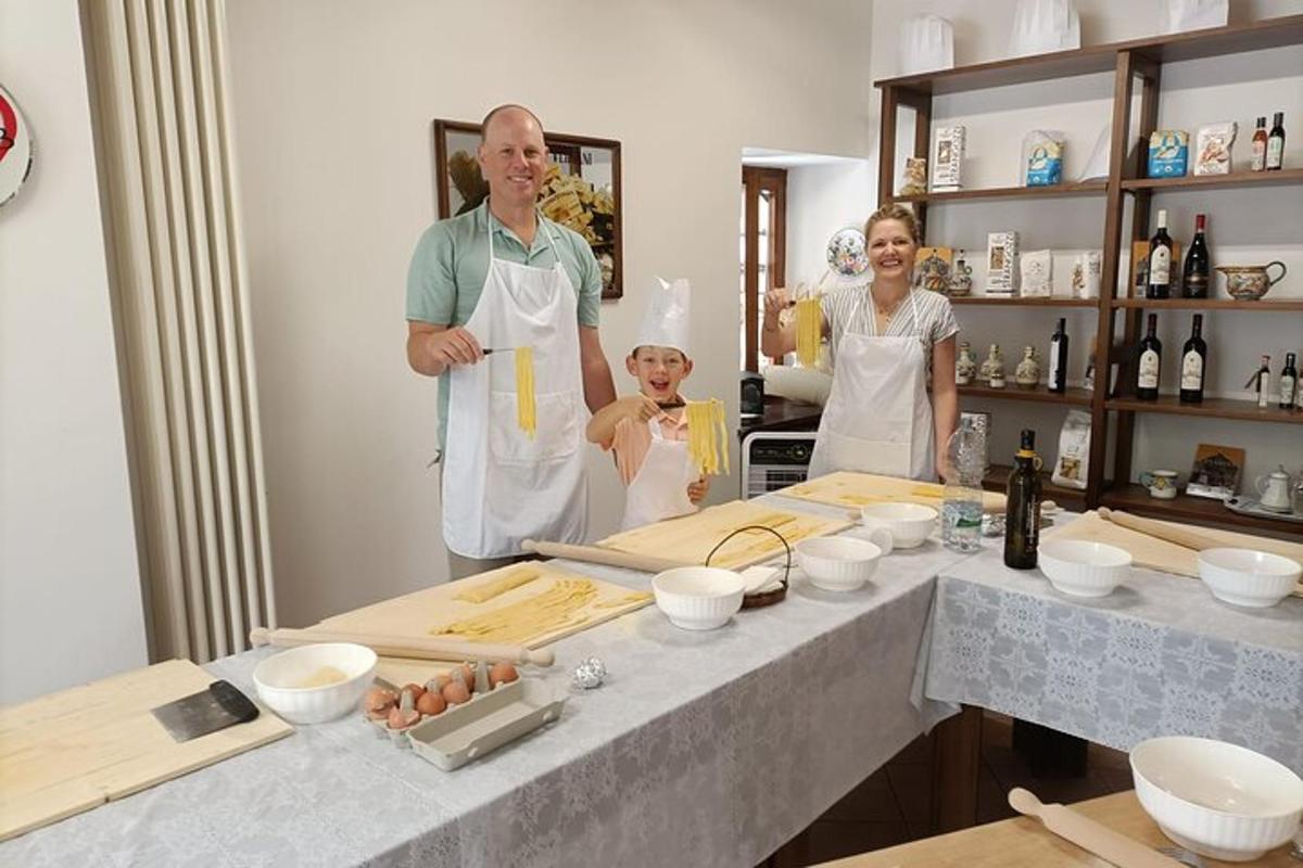 moški in dve ženski stojita v kuhinji
