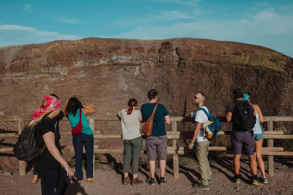 Un grupo de personas de pie frente a una roca