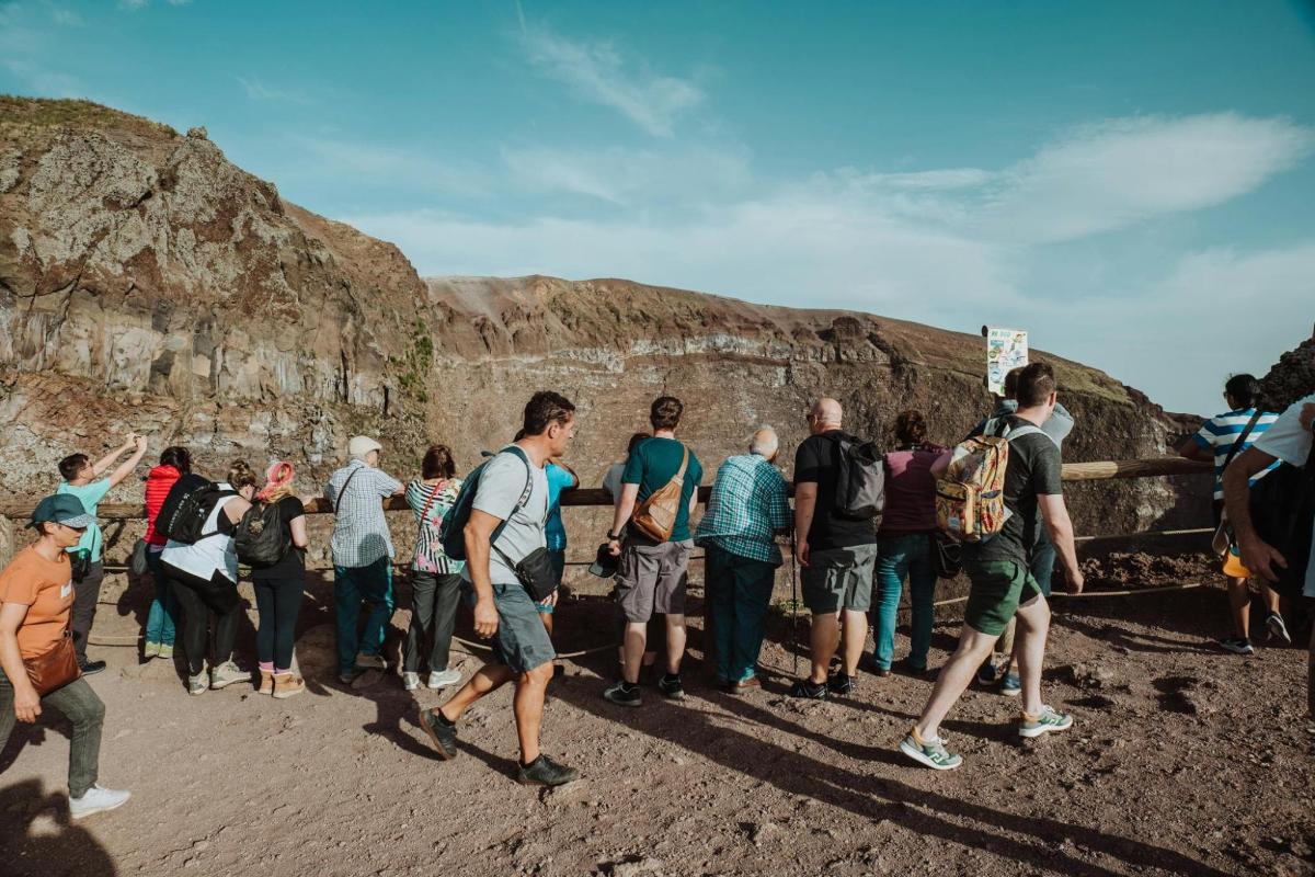 a group of people standing in front of a cliff