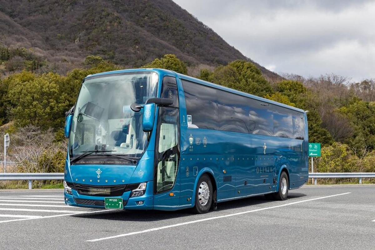 sebuah bus biru sedang melaju di jalan