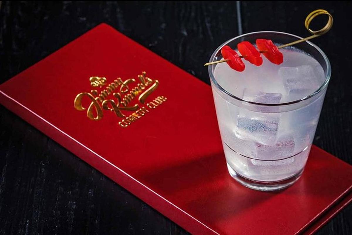 a red napkin with a glass of water and a pair of gold scissors