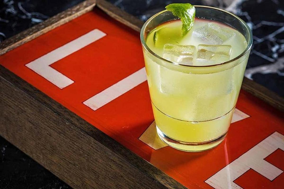 a drink with a lime on top of a coaster