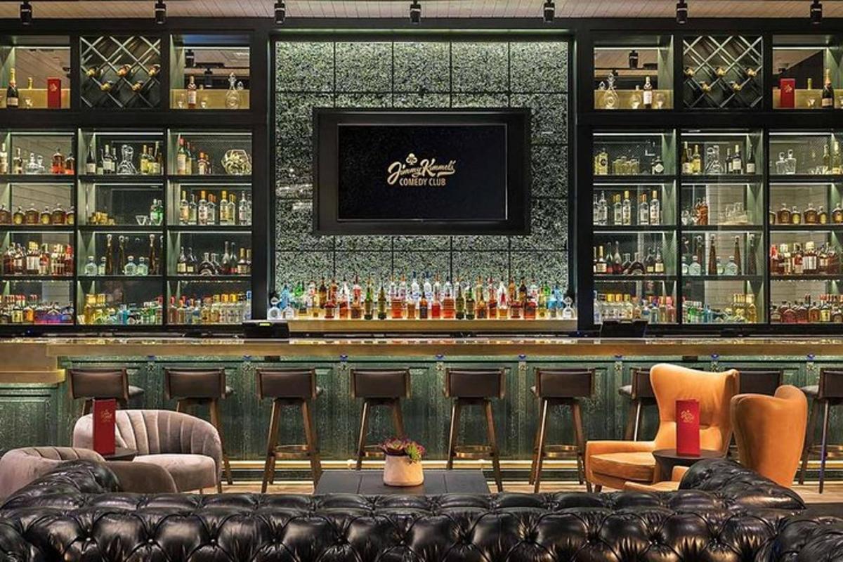 a bar with chairs and a counter with alcohol bottles