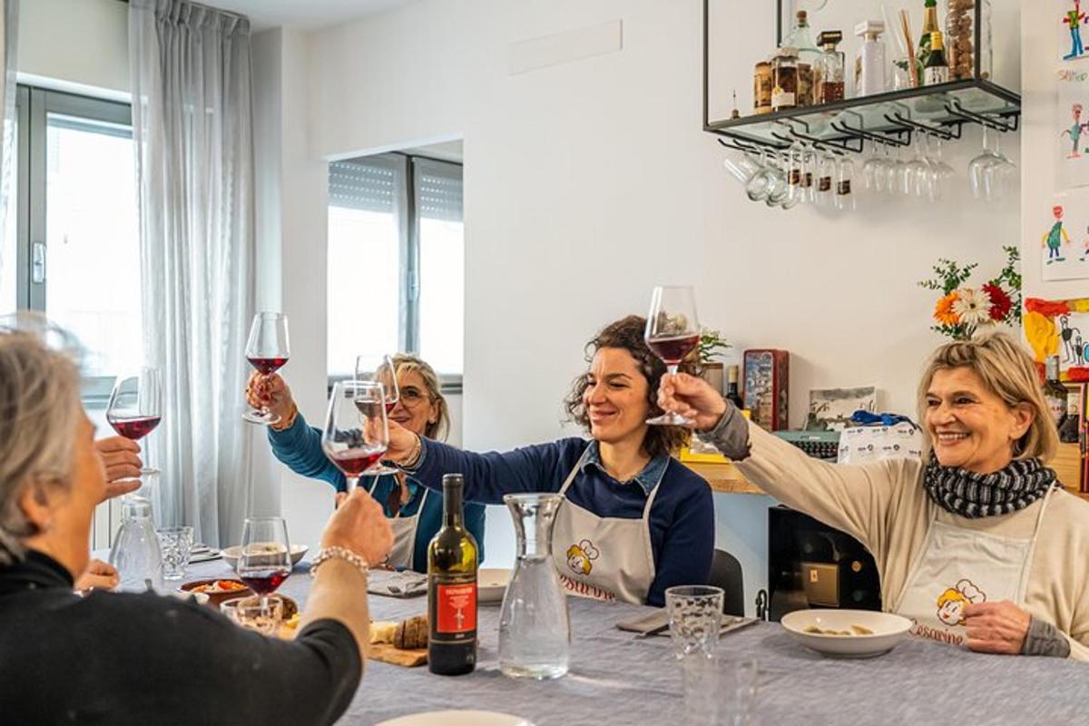 skupina žensk, ki sedijo okoli mize in pijejo vino