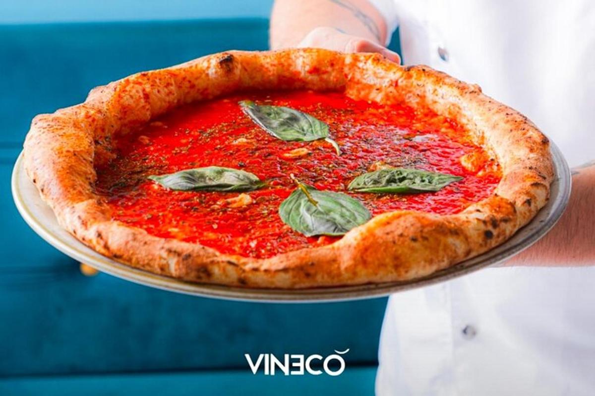 une personne tenant une pizza dans une assiette