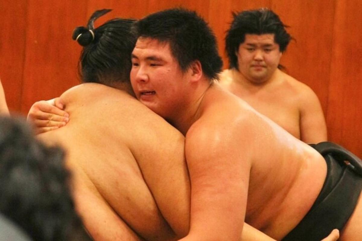 một nhóm đàn ông cởi trần đứng trong phòng tắm