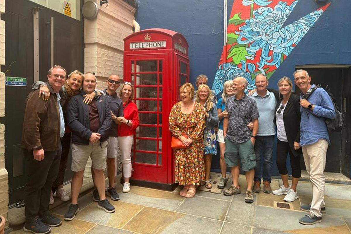 un grup de persones dretes al costat d'una cabina telefònica vermella