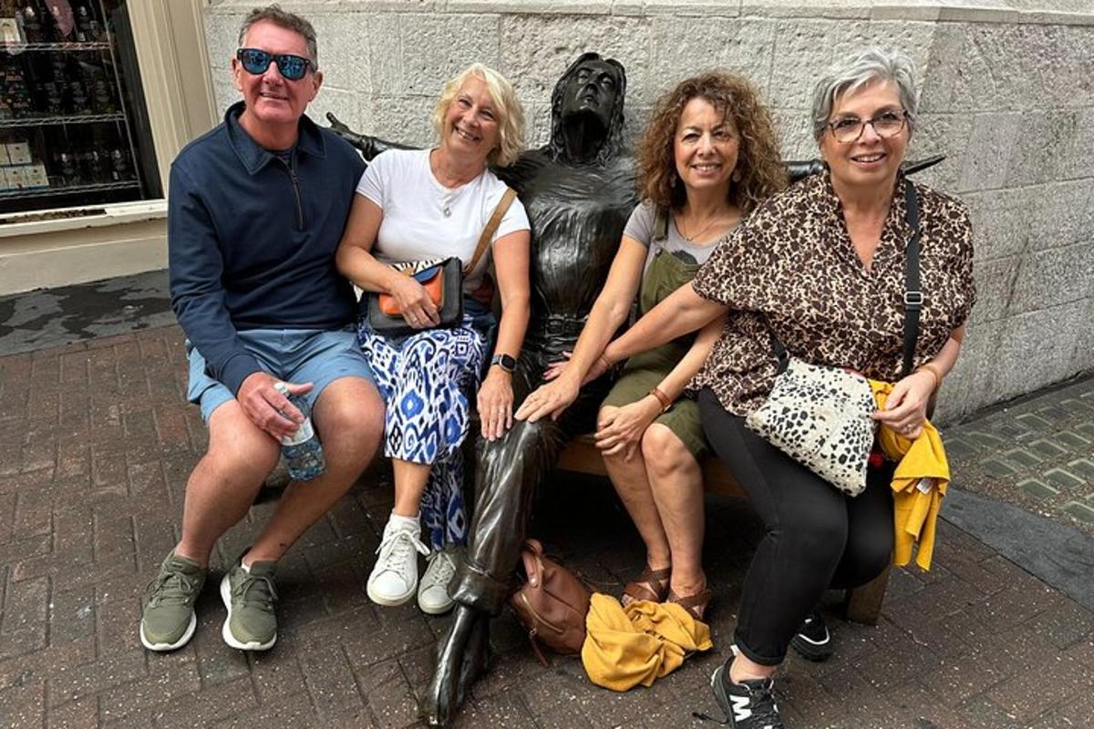 un gruppo di persone sedute accanto a una statua