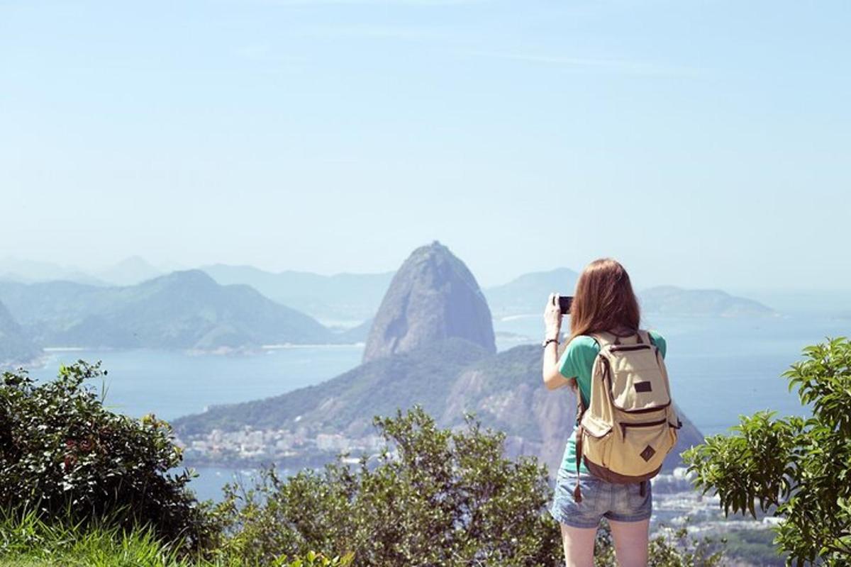 uma mulher tirando uma foto de uma montanha