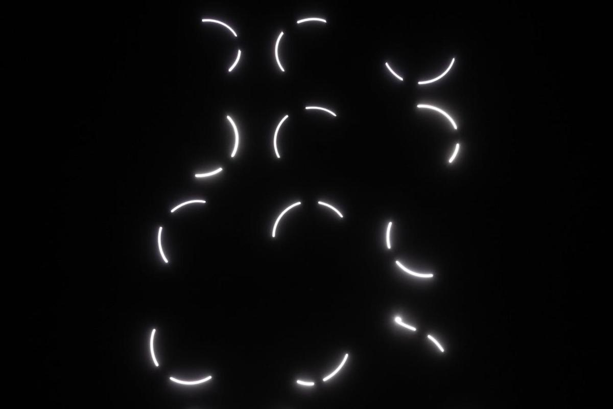a neon sign with white lights in the dark