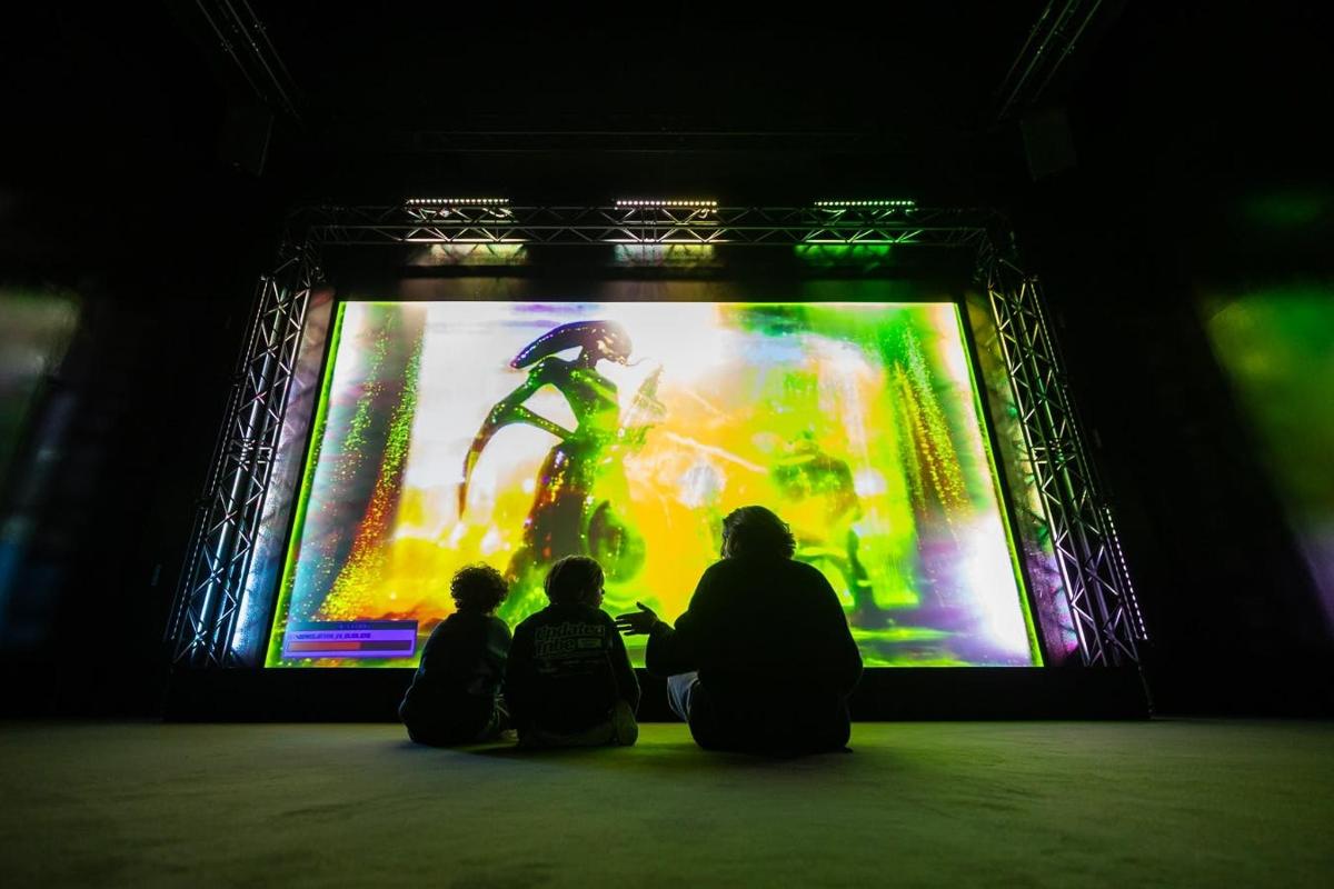 a group of people sitting in front of a video screen
