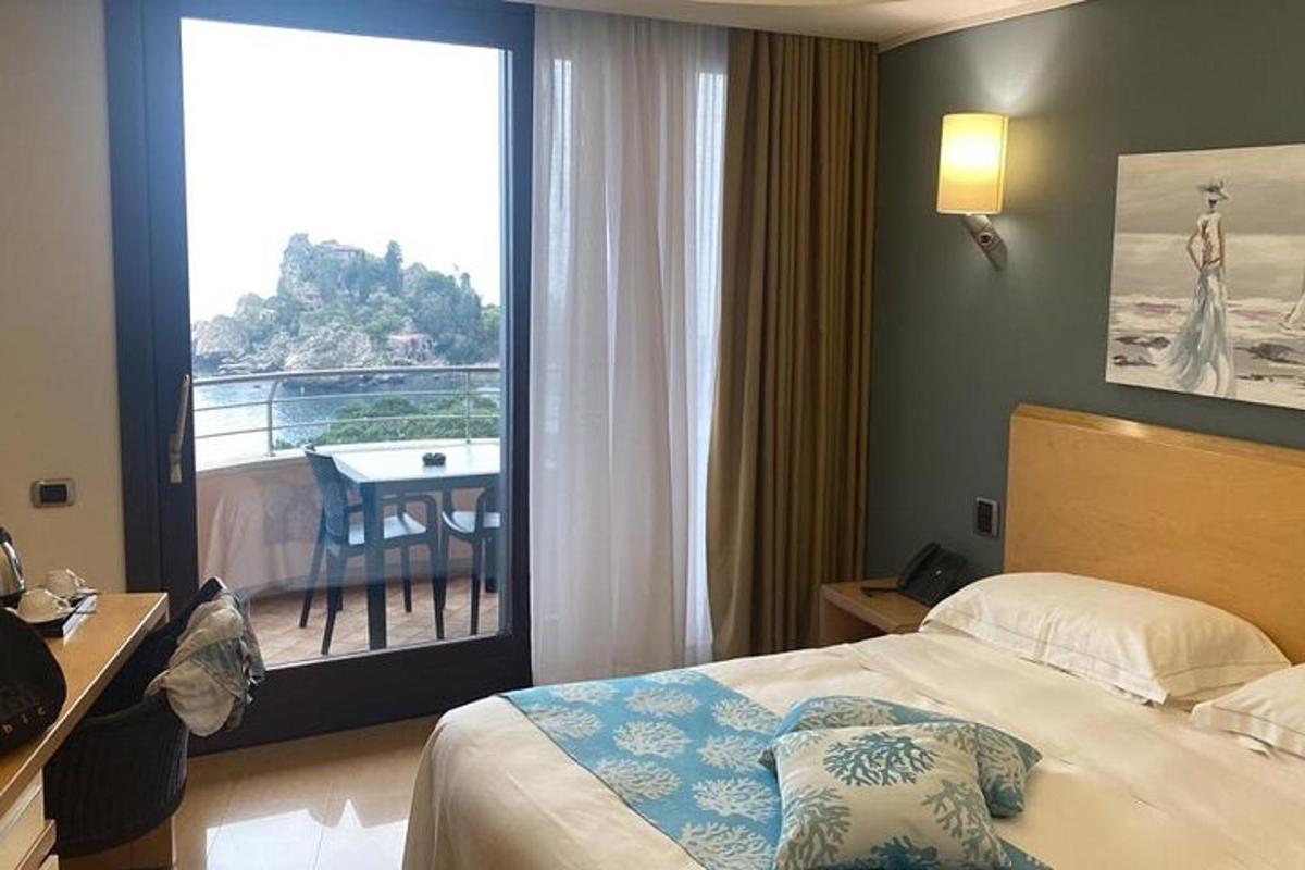 a hotel room with a bed and a view of a balcony