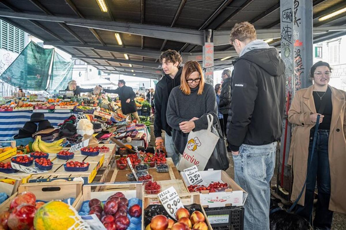 skupina lidí stojících kolem trhu s ovocem a zeleninou
