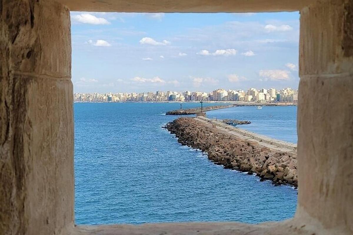 a view of the ocean through a window of a city