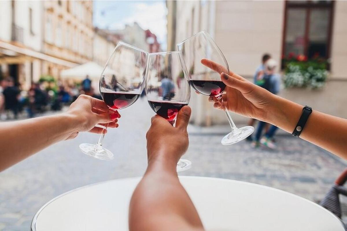 duas pessoas segurando taças de vinho tinto